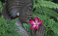 A statue of a woman holds a flower in her hands